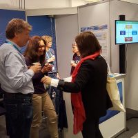 People at an information booth at a conference