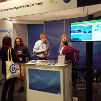 People at an information booth at a conference