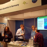 People at an information booth at a conference (close up)