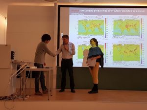 Three people on a stage in front of a presentation