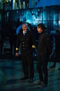 Two people in front of the dark hull of the RV Polarstern