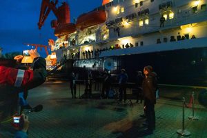 People in front of the RV Polarstern during the evening