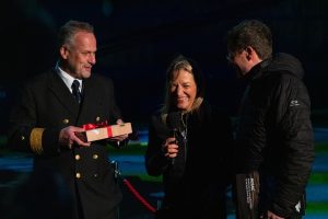 A person getting a present from two other people during a show