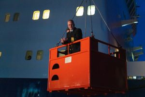 A person getting lifted onto a ship within a basket