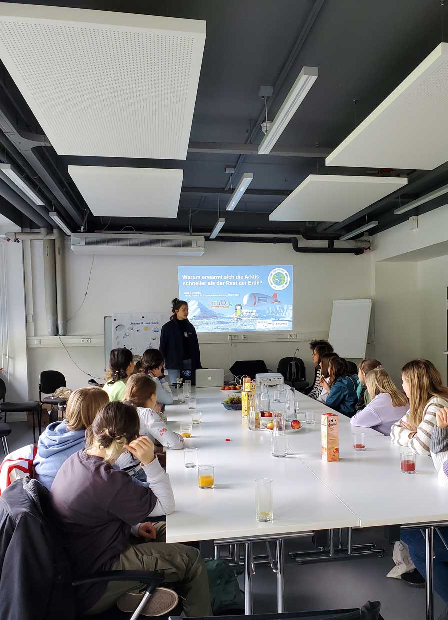 Young girls sitting at a conference table and listening to a presentation