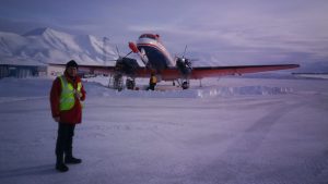A person in the Arctic in front of an aircraft