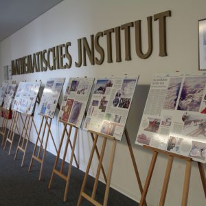 Easels in a hallway with the letters reading "Mathematisches Institut" on the wall
