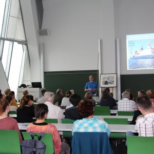 View from the back of a lecture hall with people sitting at desks