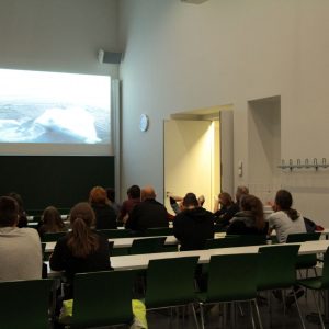 View from the back of a lecture hall with people sitting at desks
