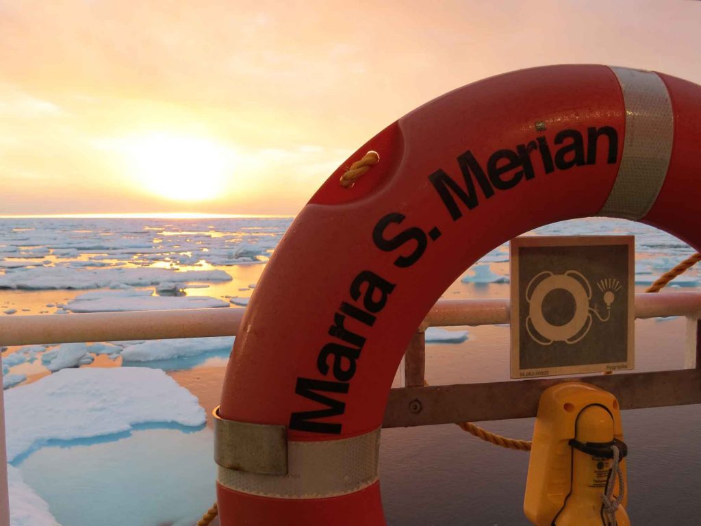 A lifeguard ring on a boat in front of patchy sea ice