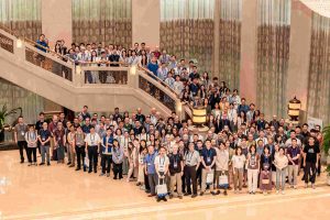 Group foto of conference members in a building.