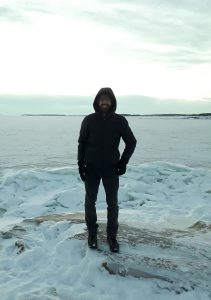 Person dressed in black in a snowy landscape looking into the camera