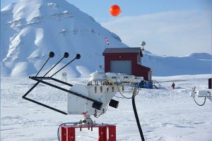 A measurement instrument on snow in front of snow covered mountains